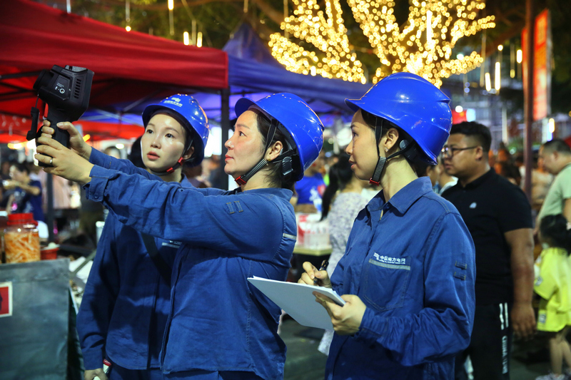 榕江供电局“巾帼班”成员正在县城开展变电设备测温工作。